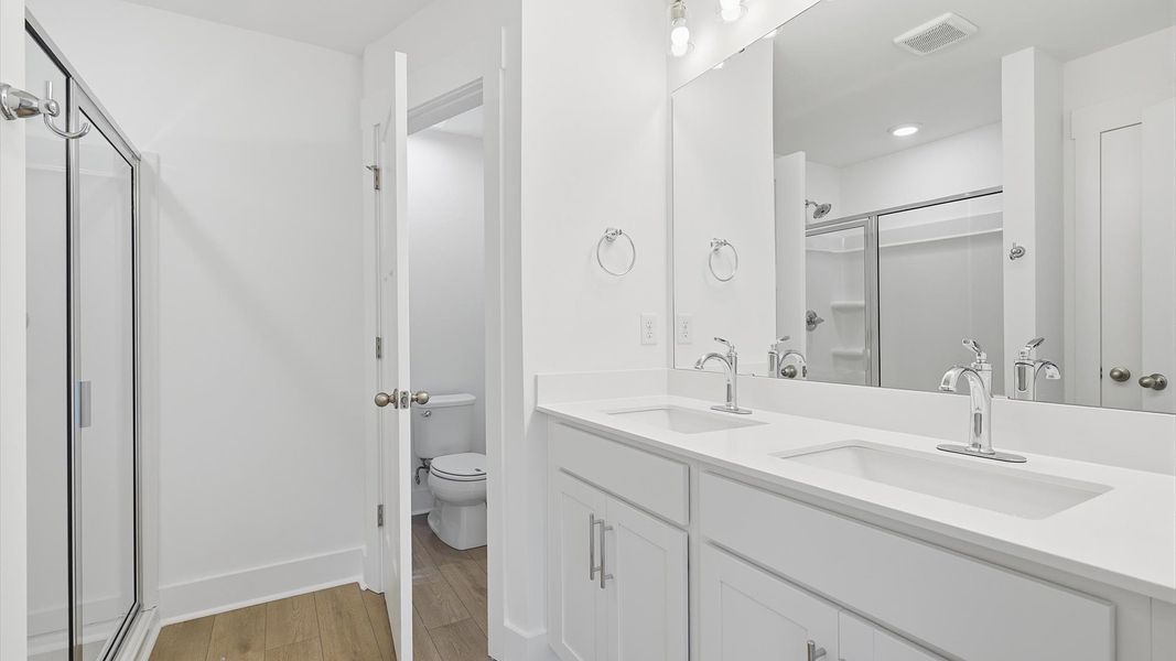 Memorable mornings begin in this elegant primary bathroom with walk-in shower and double vanity in Greenville, SC Memorable mornings begin in this elegant primary bathroom with walk-in shower and double vanity in Greenville, SC