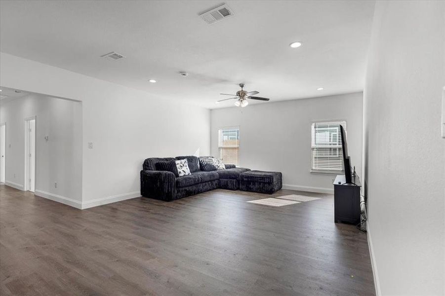 Living room featuring dark wood-style flooring, recessed lighting, and a ceiling fan Living room featuring dark wood-style flooring, recessed lighting, and a ceiling fan