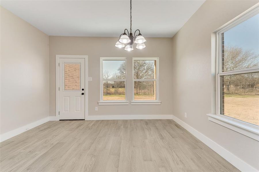 Unfurnished dining area with a notable chandelier and light wood-type flooring