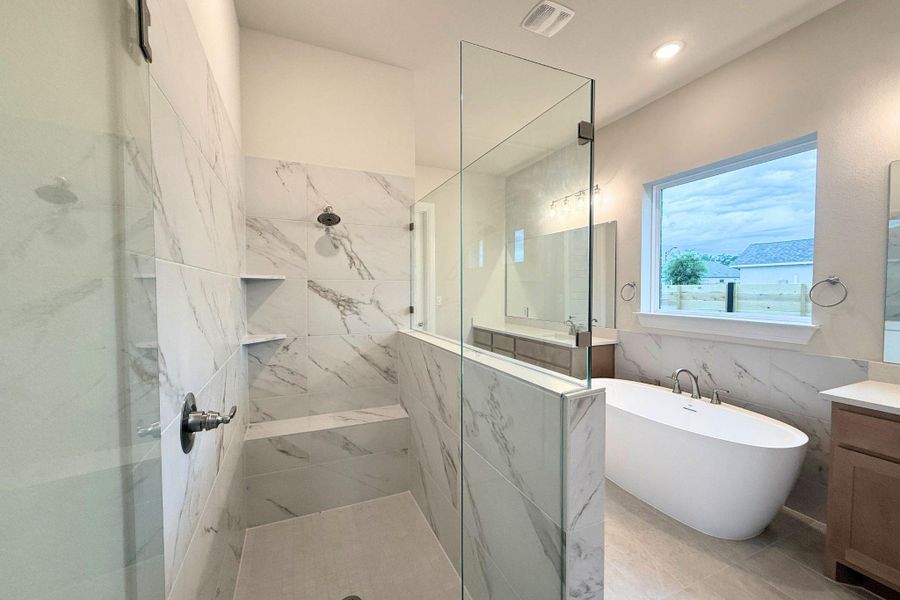 Luxurious bathing retreat featuring a spacious walk-in shower and elegant freestanding tub. Luxurious bathing retreat featuring a spacious walk-in shower and elegant freestanding tub.