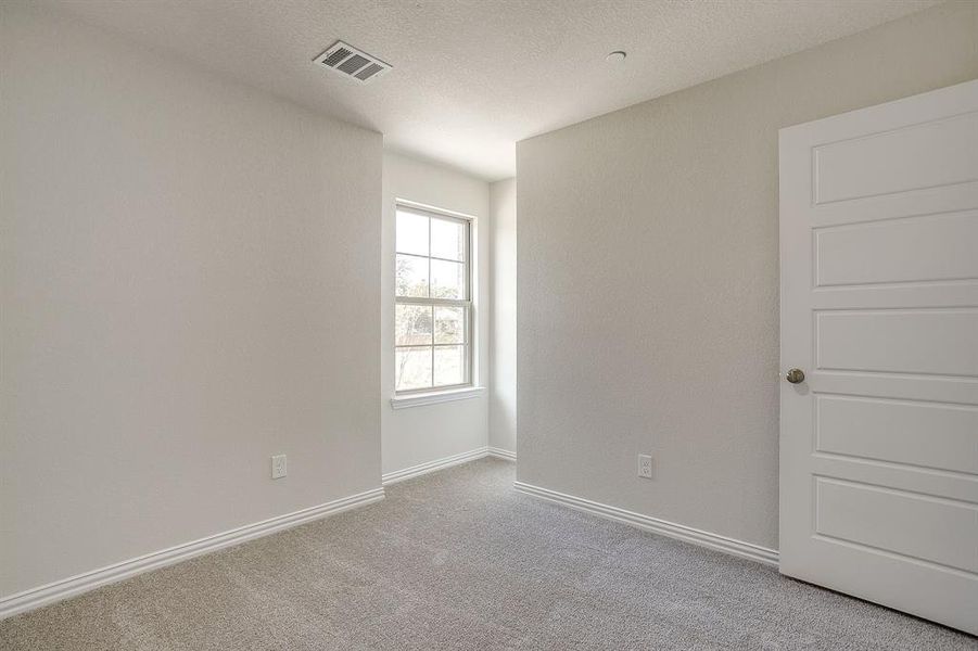 Unfurnished room featuring carpet and a textured ceiling