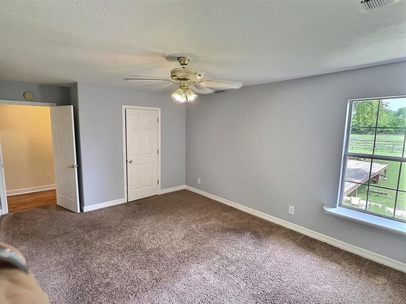 Unfurnished bedroom featuring carpet floors, a ceiling fan, and a textured ceiling