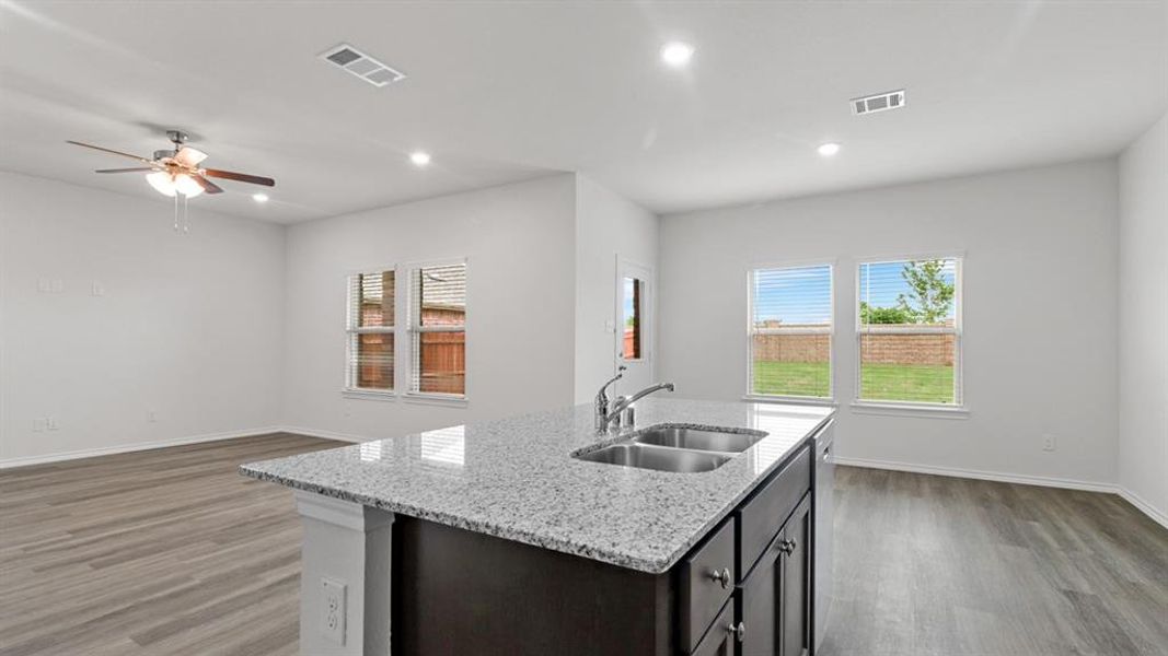 Kitchen island featuring a double basin stainless steel sink and granite countertop Kitchen island featuring a double basin stainless steel sink and granite countertop