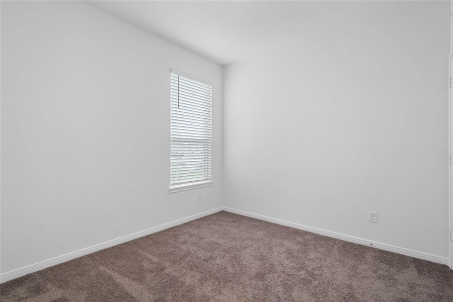 Nestled in the front of this home, the secondary bedroom offers comfort and style with plush carpeting, neutral paint tones, a large window fitted with blinds, and a generously sized closet. Nestled in the front of this home, the secondary bedroom offers comfort and style with plush carpeting, neutral paint tones, a large window fitted with blinds, and a generously sized closet.