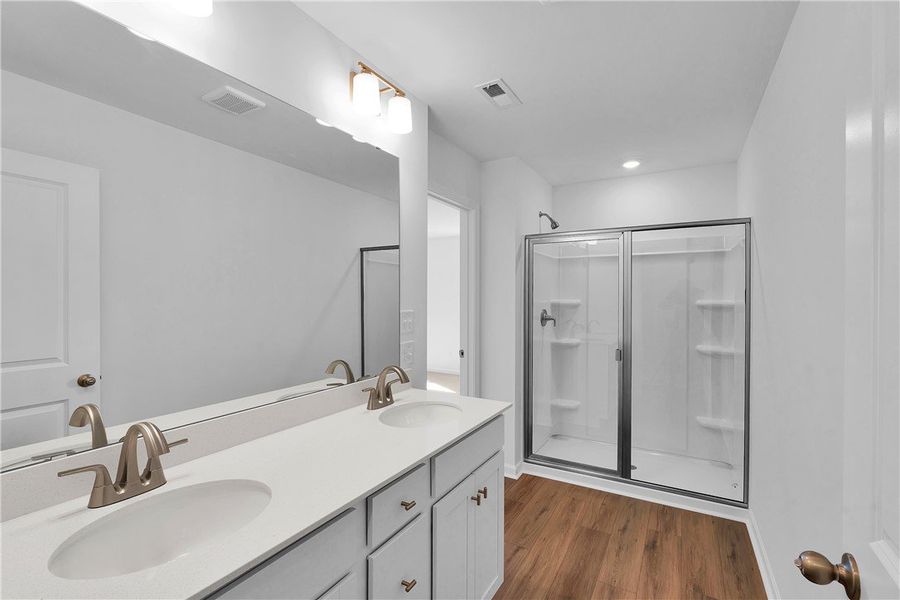 This primary bathroom features a dual vanity, a sp