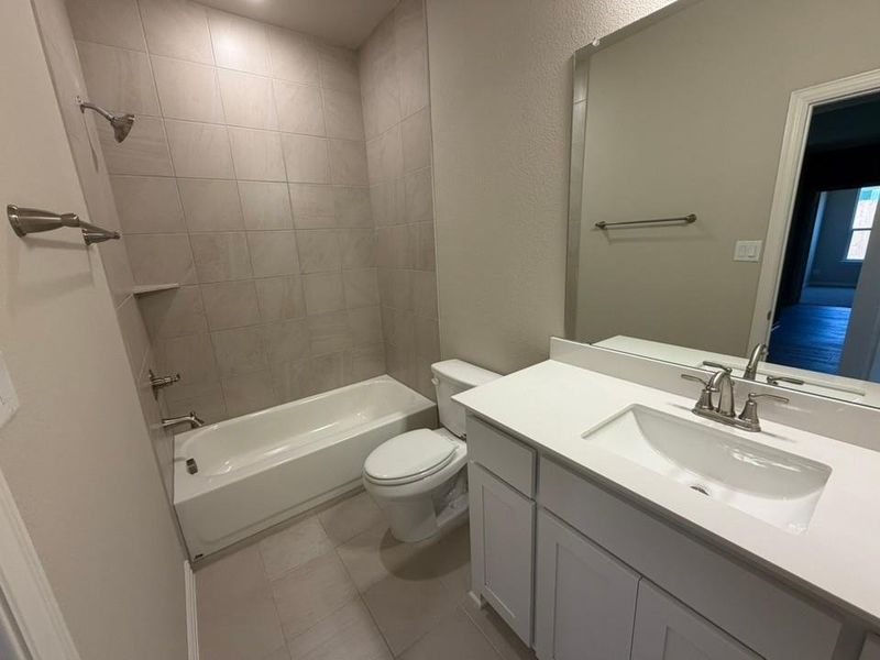 Contemporary bathroom featuring a single vanity with integrated sink, white cabinetry, and a large wall-mounted mirror