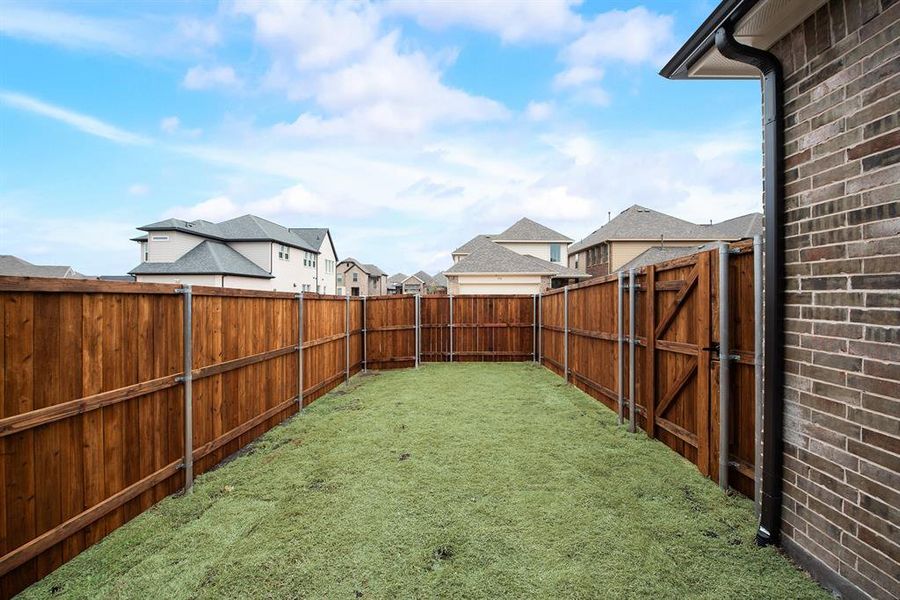 Fenced backyard with a residential view Fenced backyard with a residential view