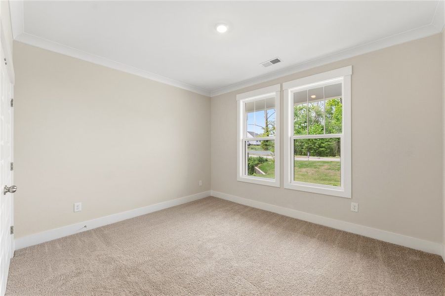 Comfortable carpeted space with bright windows, pe