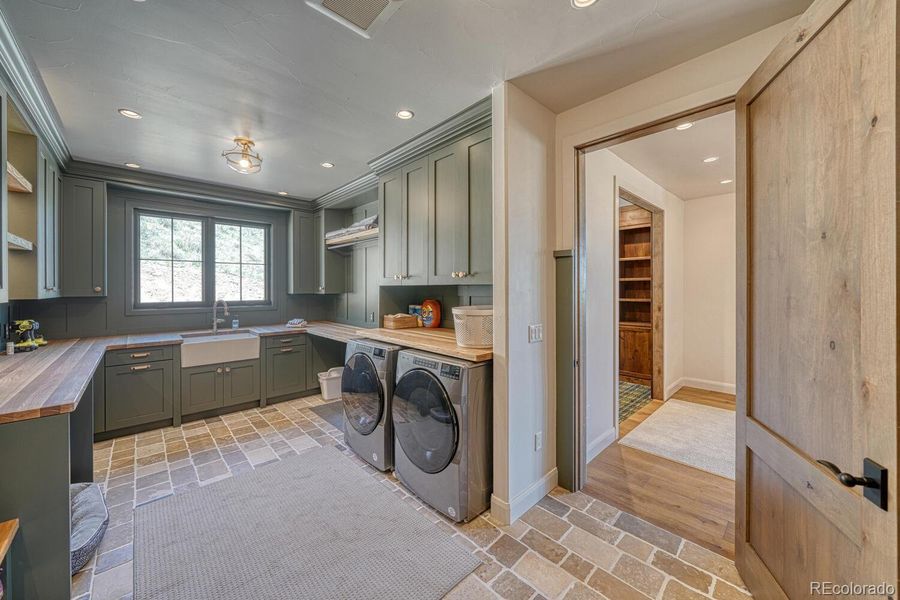 The Mudroom/Laundry room has cobblestone floors, coat closet, utility sink, Whirlpool washer/dryer, and motion activated lighting. The Mudroom/Laundry room has cobblestone floors, coat closet, utility sink, Whirlpool washer/dryer, and motion activated lighting.