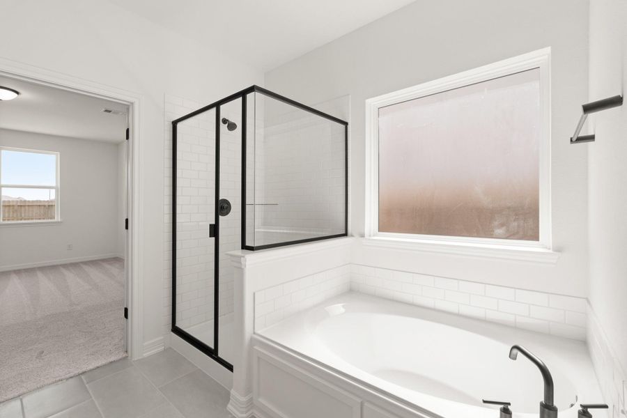 This additional view of your primary bathroom features tile flooring, fresh paint, walk-in shower, a separate garden tub, and a large walk-in closet. This additional view of your primary bathroom features tile flooring, fresh paint, walk-in shower, a separate garden tub, and a large walk-in closet.