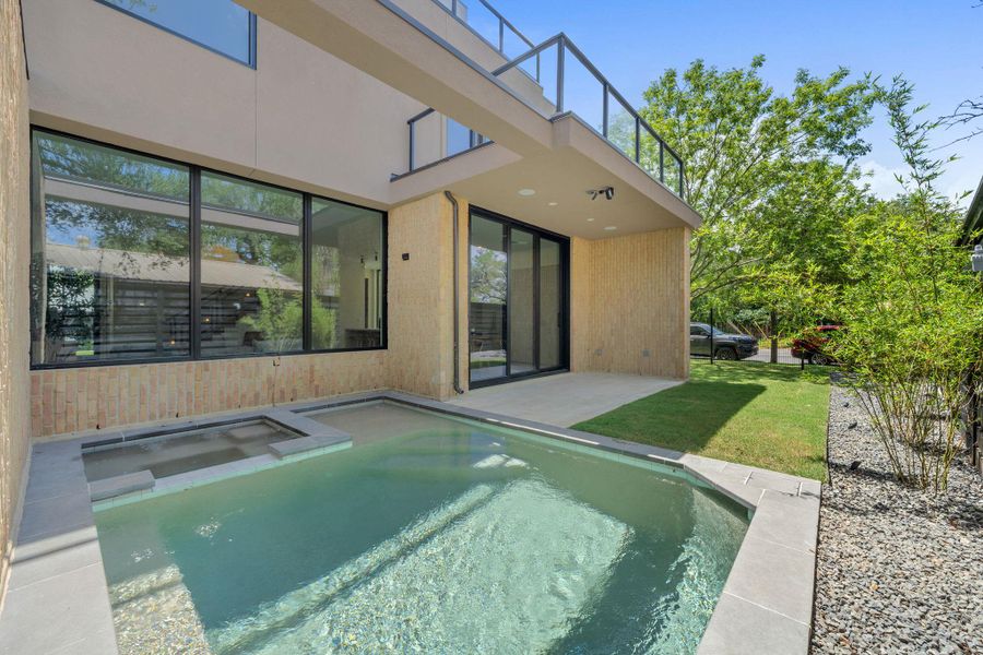An inviting backyard oasis offers a sparkling in-ground pool, spa, and a private patio.
