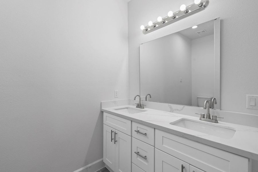 The bath features brand new quartz countertops and backsplash, and dual sinks.