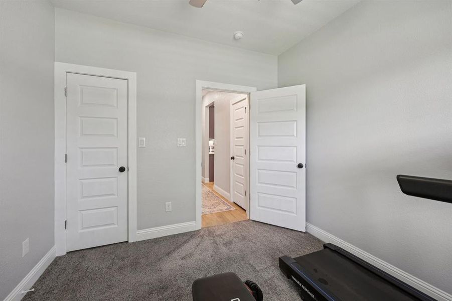 Exercise area with light carpet and ceiling fan Exercise area with light carpet and ceiling fan