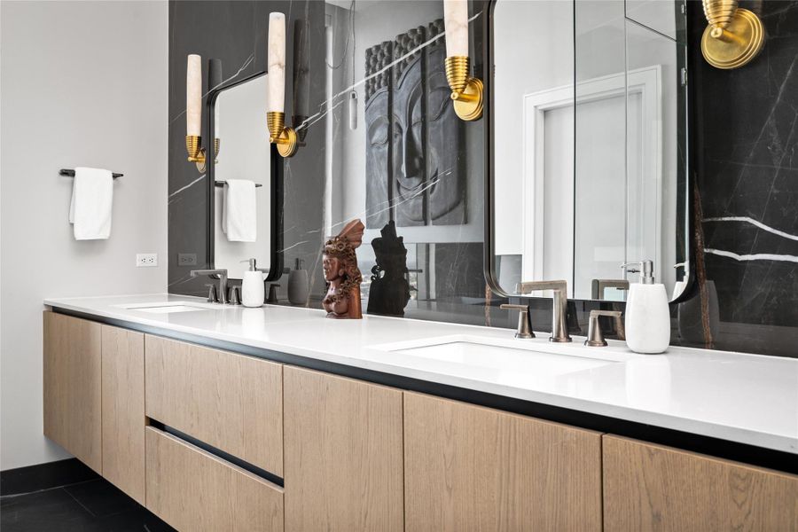 The primary bathroom boasts custom lighting, heated floors, and three walk-in closets, complemented by quartz countertops and a marble backsplash for a luxurious finish.