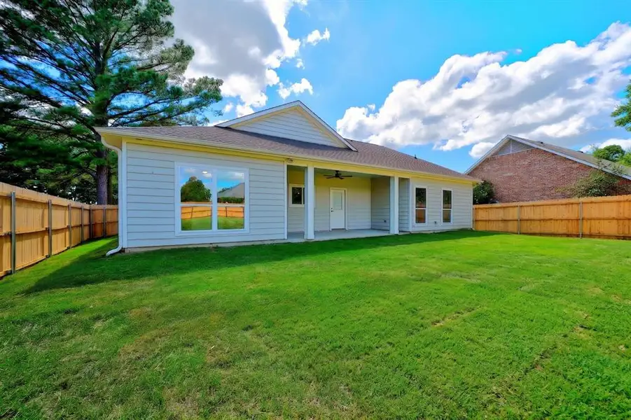 Expansive green lawn with a newly installed wood privacy fence, providing a private outdoor area