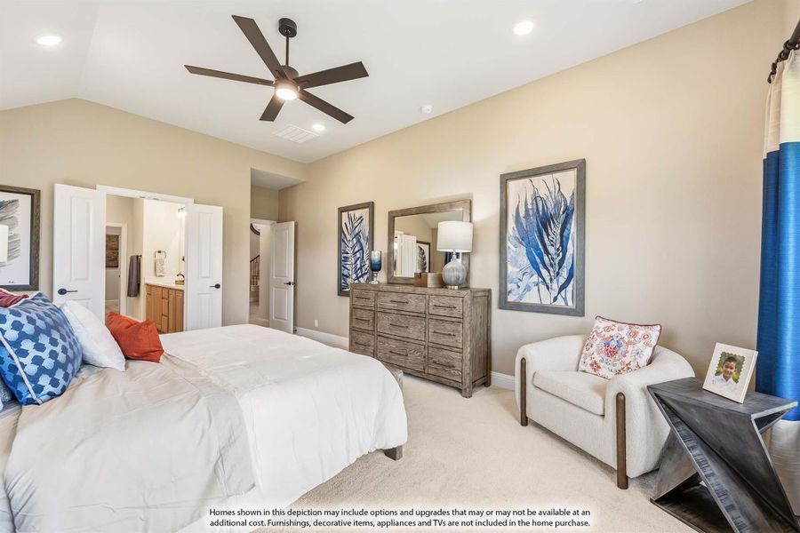 Bedroom with ceiling fan, wood dresser, accent chair, and ensuite bathroom doorway visible