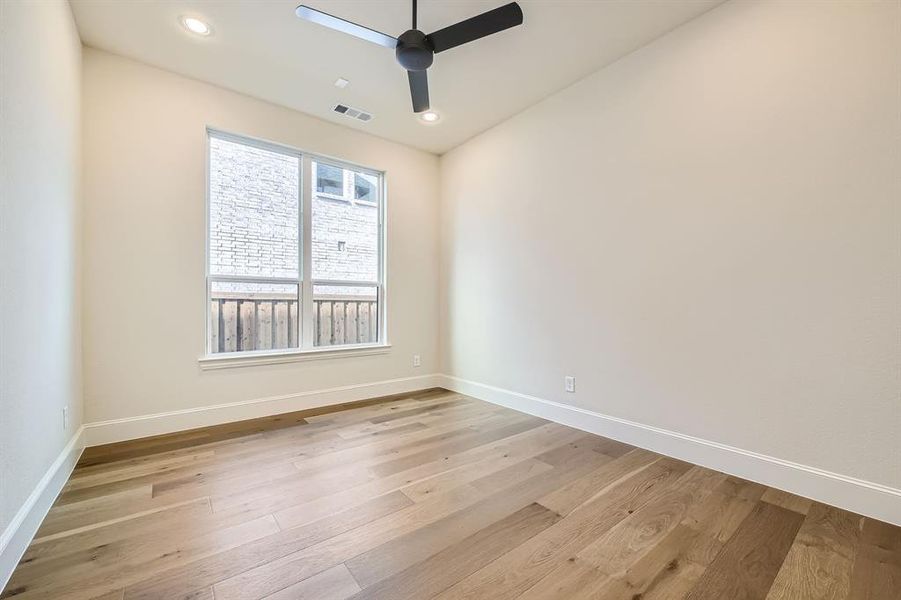 1st Floor secondary bedroom featuring light wood-type flooring and ceiling fan