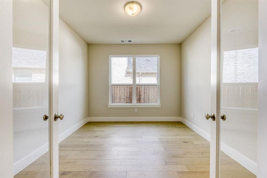 Empty room with french doors and light wood-type flooring