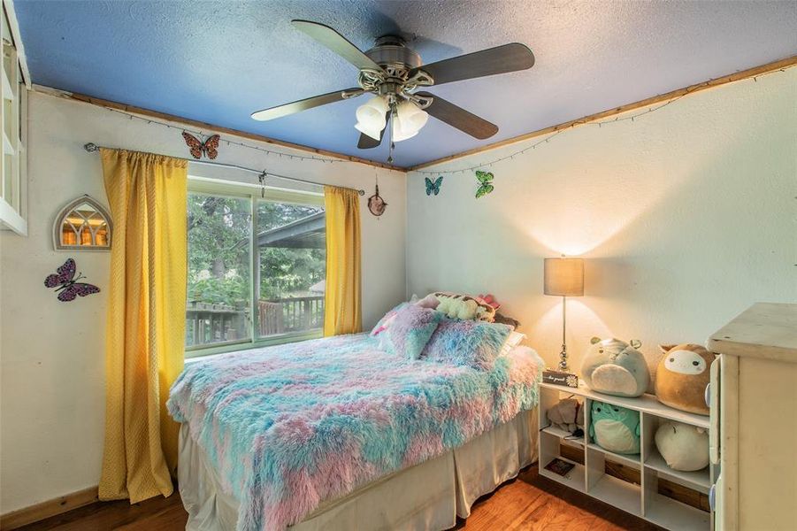 Secondary bedroom with hardwood floors, natural light, and views of the surrounding property. Secondary bedroom with hardwood floors, natural light, and views of the surrounding property.
