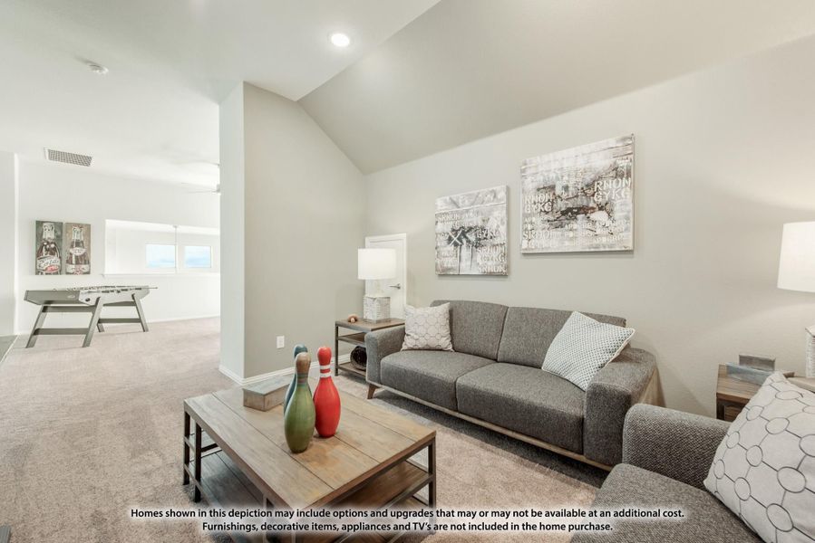 Bonus room with vaulted ceiling, gray sofa, carpet floors, and foosball table in background