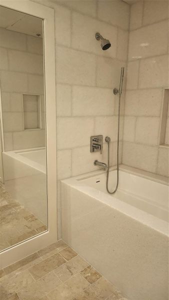 Thassos Marble Walls & Waterfall surround for Victoria+Albert extra-deep soaking tub. Inline hot water booster ensures maximum hot water to fill this custom imported Limestone resin bathtub with multiple showerhead options.