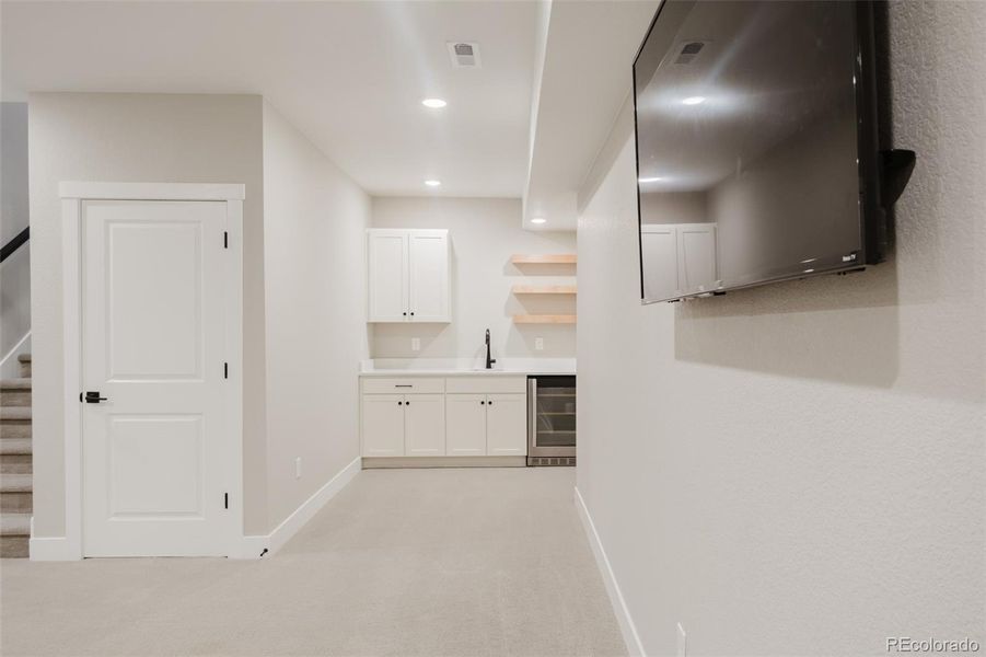 The family room has a built-in wet bar with lots of storage, a wine fridge and open shelving. The family room has a built-in wet bar with lots of storage, a wine fridge and open shelving.