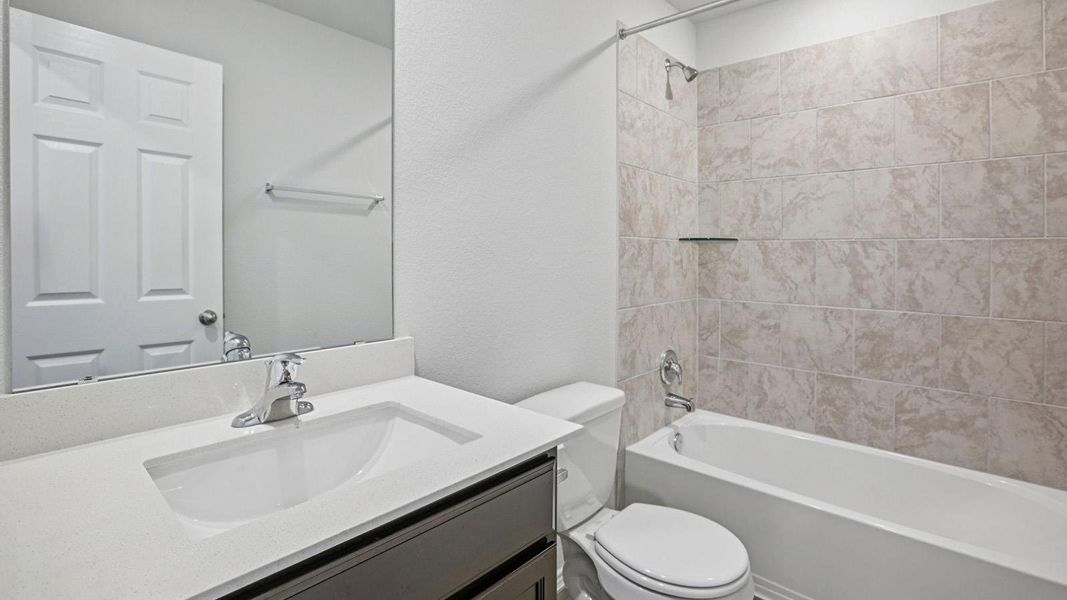 Full bathroom with vanity, tub / shower combination, and a textured wall