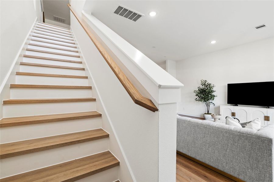 This staircase connects the main living space to the upper level, enhancing the home’s open-concept design.