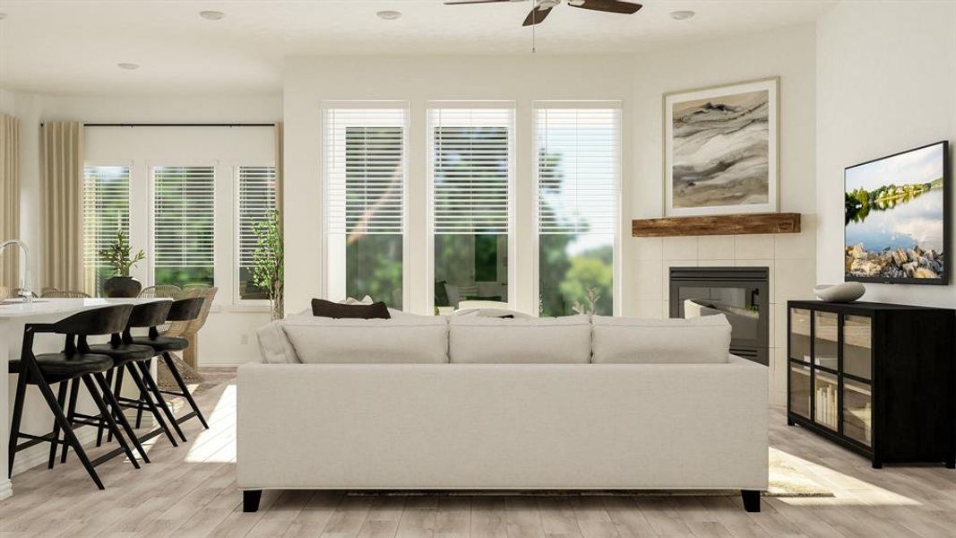 Living room with light hardwood / wood-style flooring, ceiling fan, and a tile fireplace