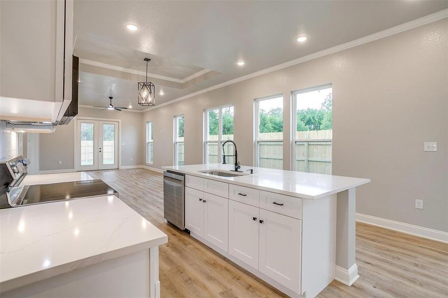 Kitchen featuring crown molding, appliances with stainless steel finishes, a sink, white cabinets, and light wood-style floors Kitchen featuring crown molding, appliances with stainless steel finishes, a sink, white cabinets, and light wood-style floors