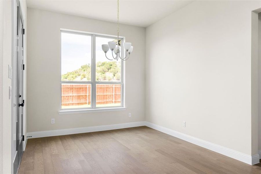 Unfurnished room featuring light hardwood / wood-style floors and a chandelier