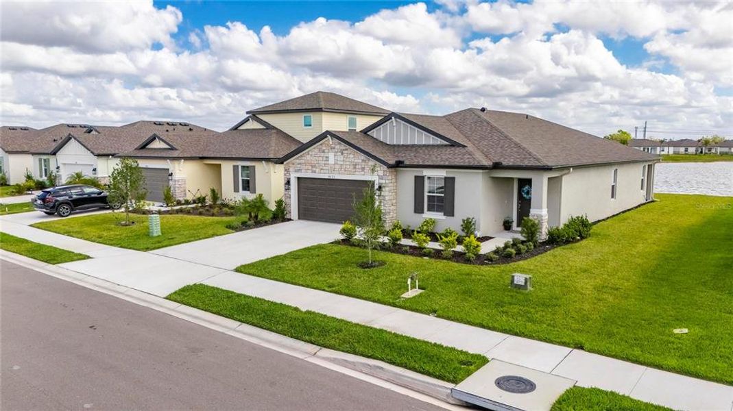 Front exterior of a new home in Summerwoods, Parrish, FL, highlighting curb appeal (Image 24).