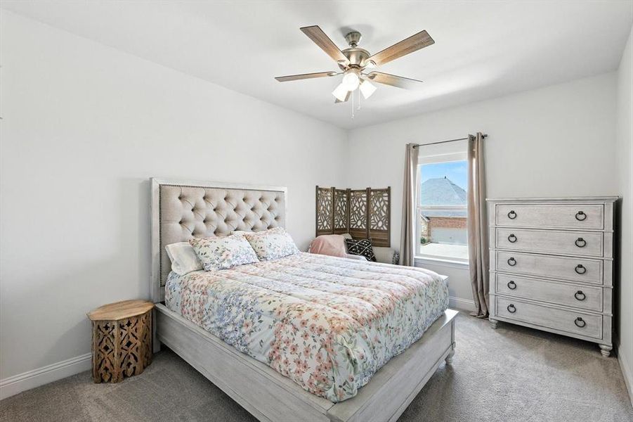Carpeted bedroom featuring baseboards and a ceiling fan