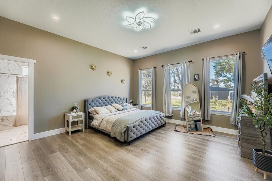 Bedroom with light wood-style floors, multiple windows, and recessed lighting Bedroom with light wood-style floors, multiple windows, and recessed lighting