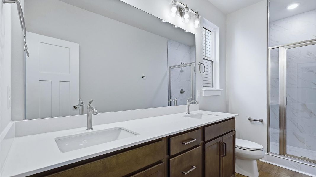 Notable primary suite with dual vanities and walk-in shower in this prime Fountain Inn home Notable primary suite with dual vanities and walk-in shower in this prime Fountain Inn home