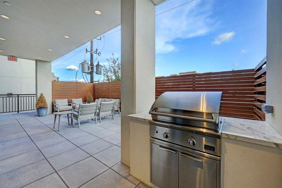 The shared terrace is furnished with a grilling area, seating and a fire pit.