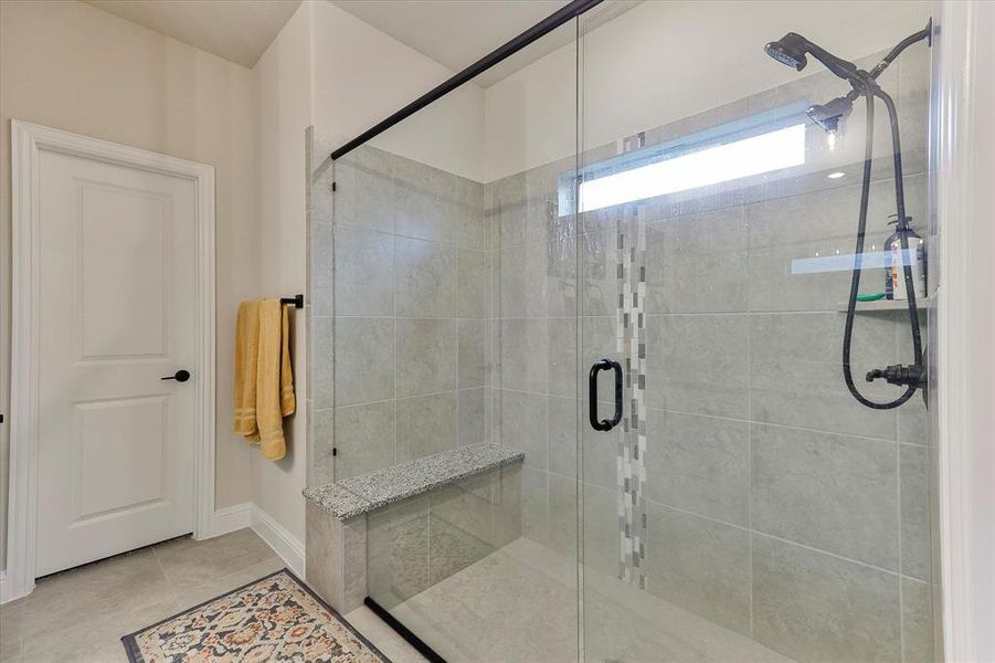 The spa-like primary bath features granite countertops, dual sinks, overized shower with built in bench and walk in closet The spa-like primary bath features granite countertops, dual sinks, overized shower with built in bench and walk in closet
