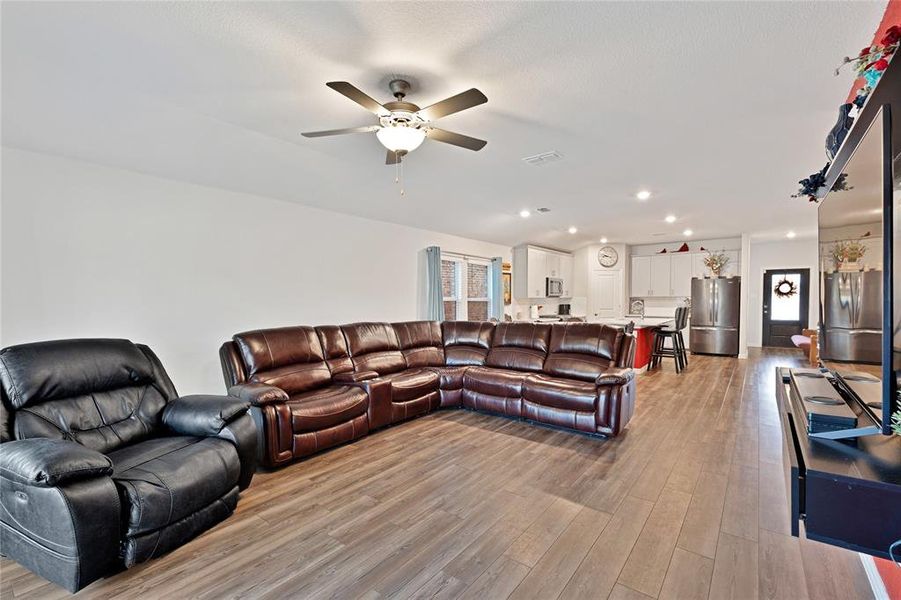 Living room with recessed lighting, light wood-style floors, and ceiling fan