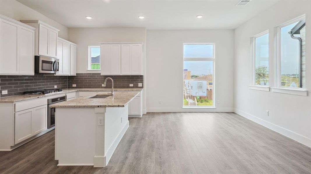 Open-concept kitchen and living area featuring wood-finish flooring