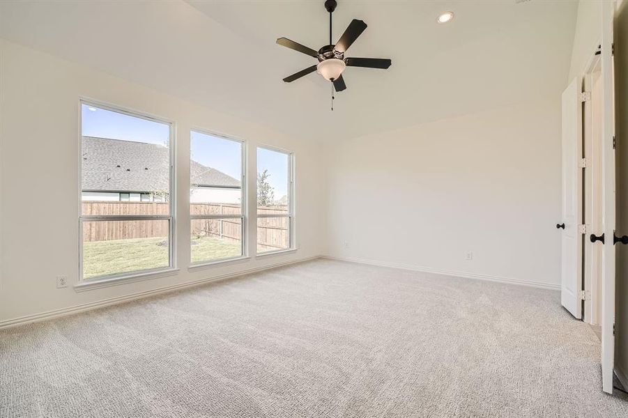 Carpeted spare room featuring ceiling fan