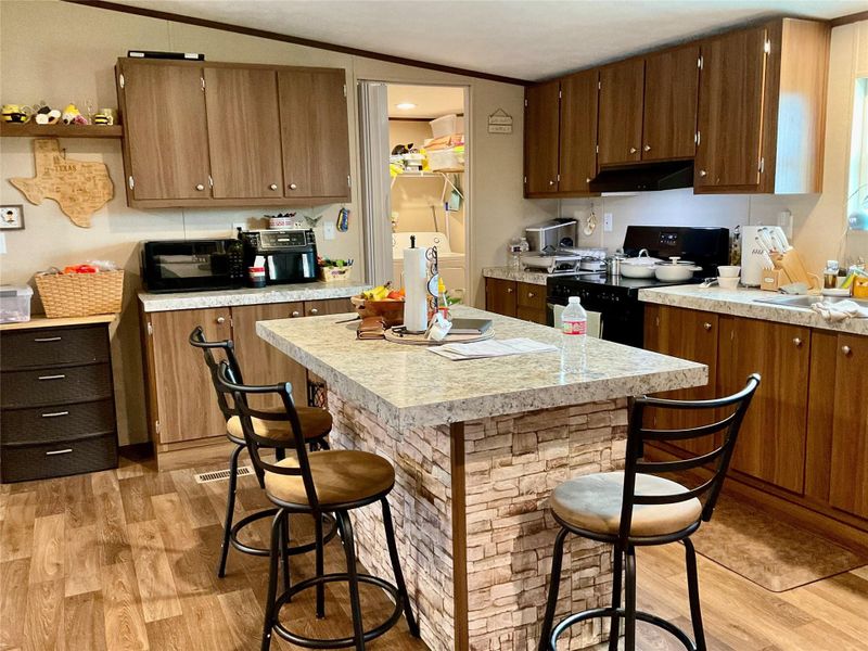 Kitchen featuring a central island with stone-look facade and a light-toned countertop