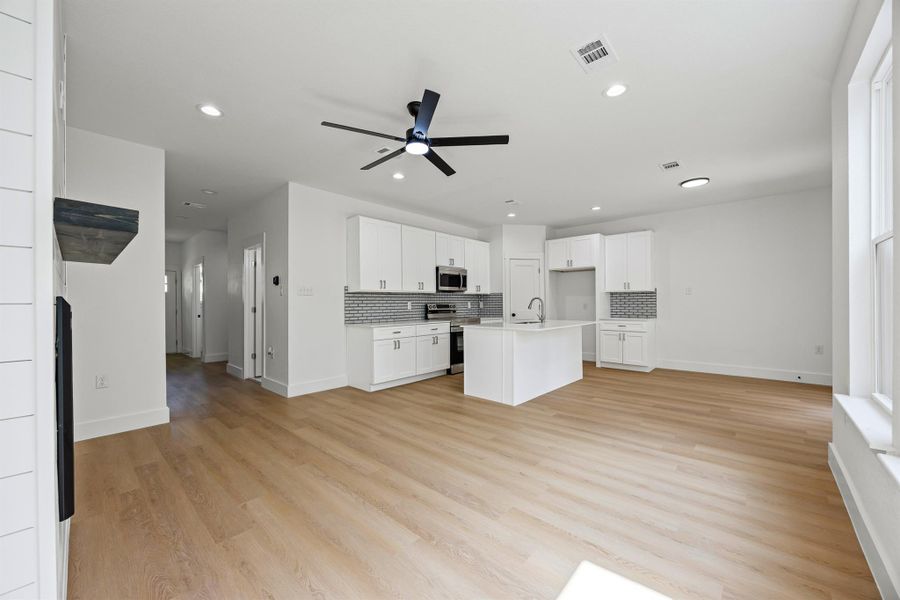 Unfurnished living room with ceiling fan, recessed lighting, and light wood finished floors Unfurnished living room with ceiling fan, recessed lighting, and light wood finished floors