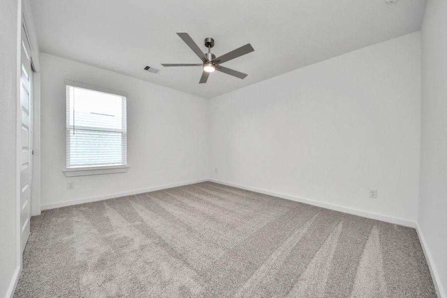 Secondary bedroom features plush carpeting, large windows that let in plenty of natural light, bright paint, and spacious closets. Sample photo of completed home with similar floor plan. Actual colors and selections may vary. Secondary bedroom features plush carpeting, large windows that let in plenty of natural light, bright paint, and spacious closets. Sample photo of completed home with similar floor plan. Actual colors and selections may vary.