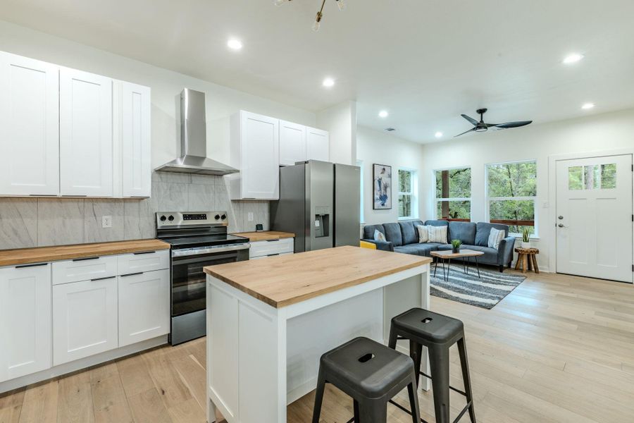 An open-concept living area features a modern kitchen and a naturally illuminated living room. An open-concept living area features a modern kitchen and a naturally illuminated living room.