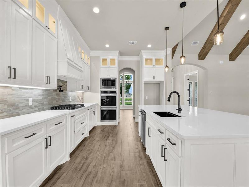 Kitchen featuring a sink, arched walkways, stainless steel appliances, tasteful backsplash, and recessed lighting Kitchen featuring a sink, arched walkways, stainless steel appliances, tasteful backsplash, and recessed lighting