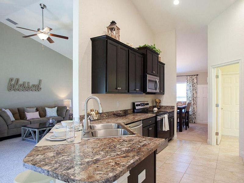 Open kitchen with walk-in pantry and counter-height breakfast bar - Ryleigh home plan by Highland Homes