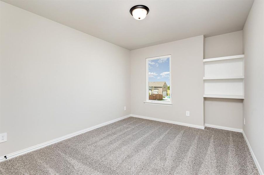 Carpeted spare room with baseboards