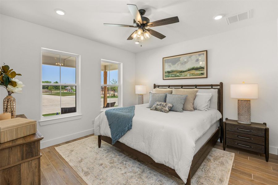 Well-lit sleeping quarters with a ceiling fan, wood flooring, and ample natural light.
