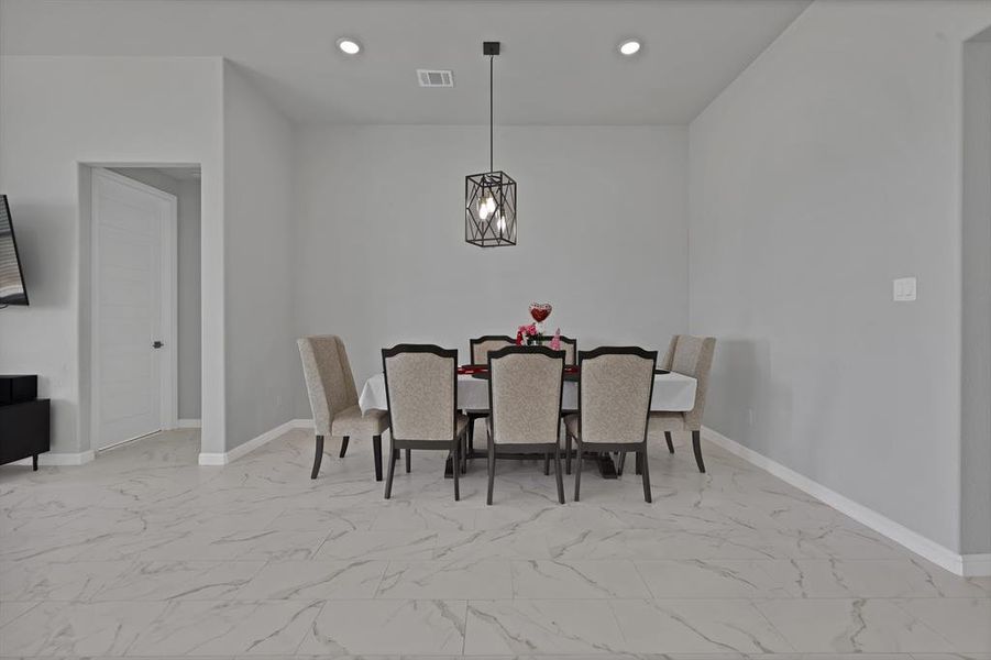 Dining space with marble look floor tile, baseboards, visible vents, and recessed lighting