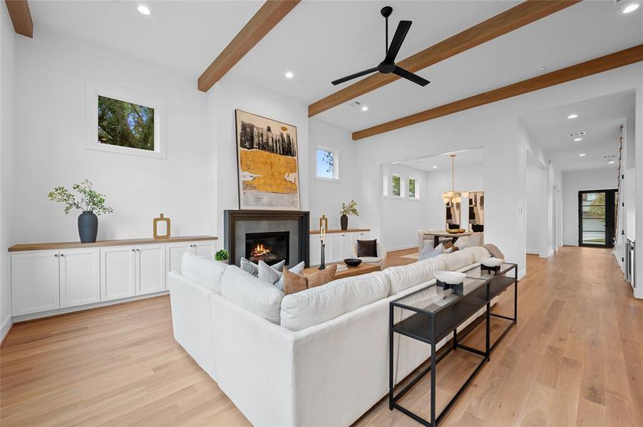 Open floor plan with huge great room with 13' ceiling and white oak wood beam ceiling detail open to dining room and kitchen overlooking backyard